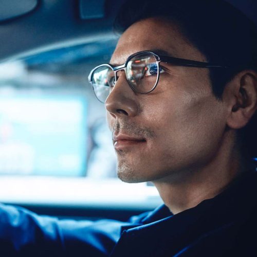 Mężczyzna w okularach prowadzący samochód – okulary korekcyjne do jazdy dla kierowców.